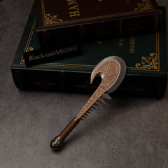 Patu replica (15cm die-cast zinc alloy war club) — toothed, bronze-toned club beside stacked books, by BlacksmithSONG.