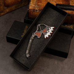 War Club replica — resting in its foam-lined gift box beside old hardcover books.