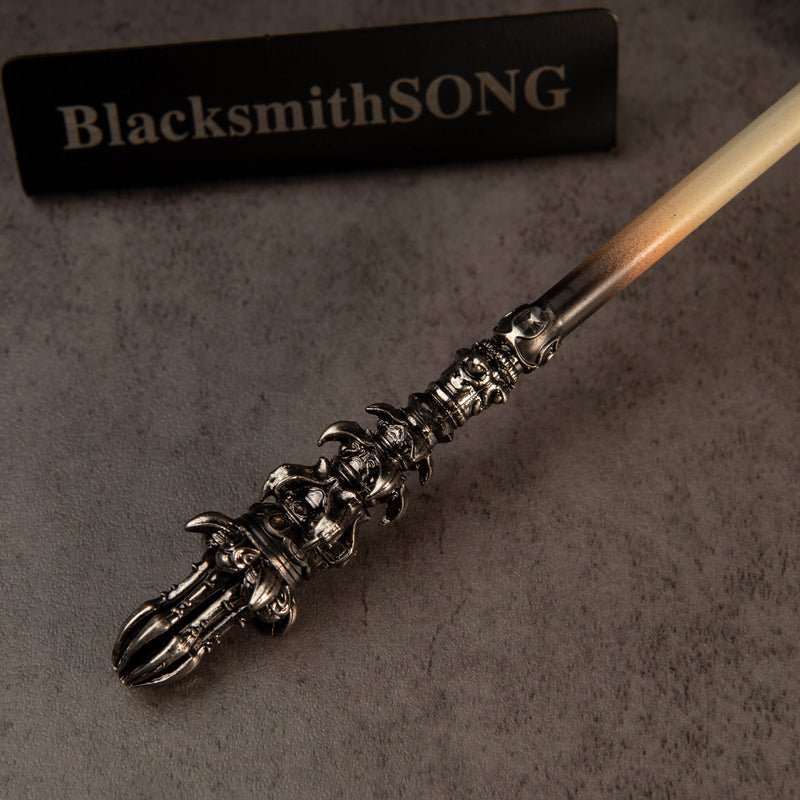Chitin Staff replica — close-up of the ornate metal end and the cream-colored shaft.
