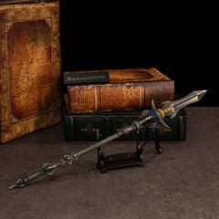 Chu-Bai Spear replica — resting on the small display stand in front of stacked books.