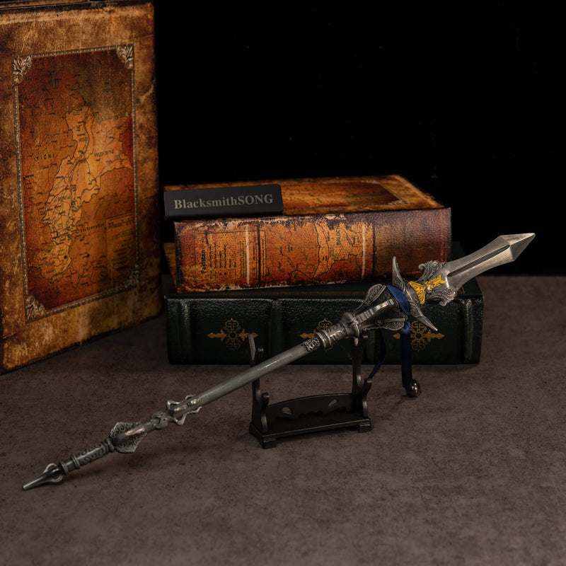 Chu-Bai Spear replica — resting on the small display stand in front of stacked books.