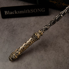 Cloud-Patterned Stone Staff replica — close-up of the gold-toned carved end cap.