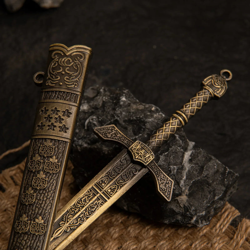 Close-up macro shot of the hilt and crossguard of the Banished Knight's Greatsword replica, showing antique bronze details.