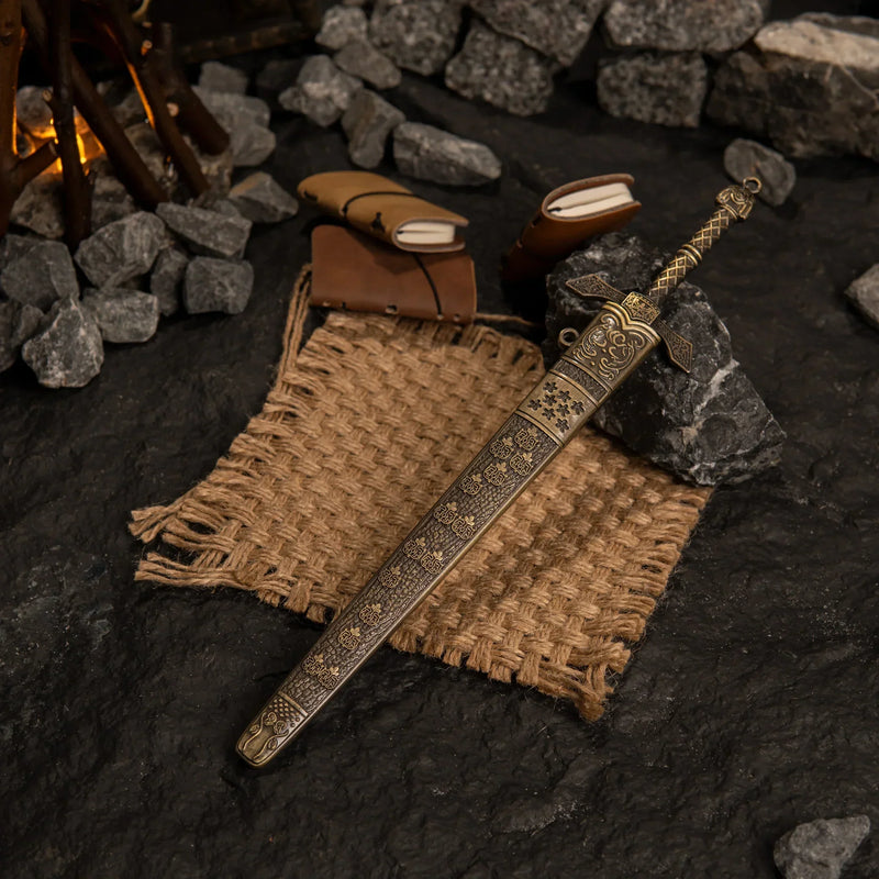 Top-down view of the Banished Knight's Greatsword and scabbard on a textured dark surface with burlap and leather props.