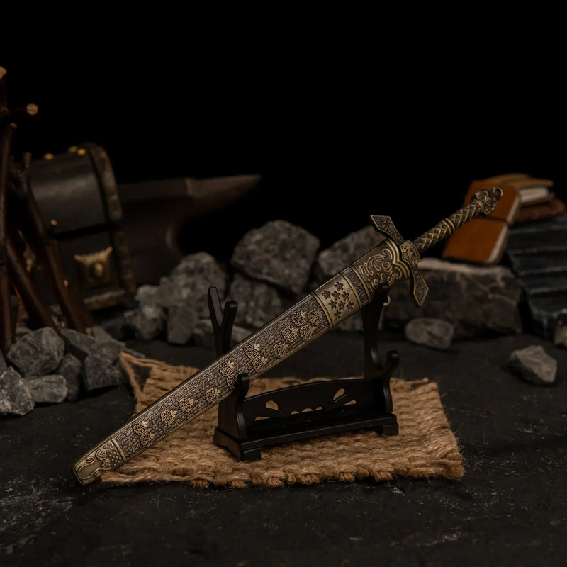 Banished Knight's Greatsword replica displayed horizontally on a small stand over a piece of burlap cloth.