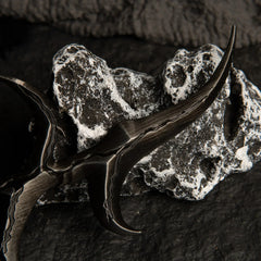 Close-up detail of the Black Knife dagger resting on a white and grey textured rock.