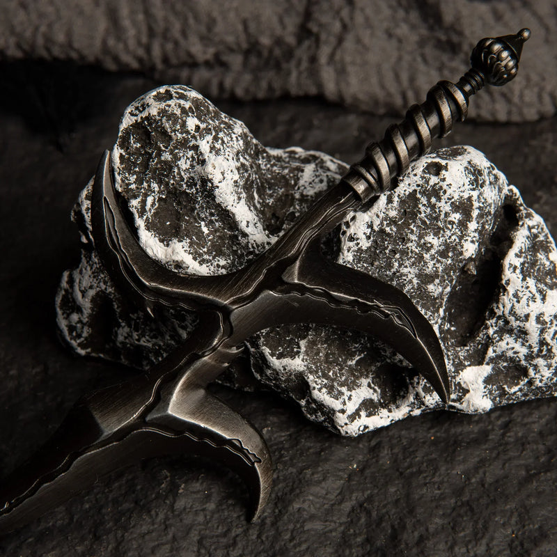 Close-up macro shot of the Black Knife metal replica, focusing on the dark, uneven, wave-like texture of the blade and hilt.