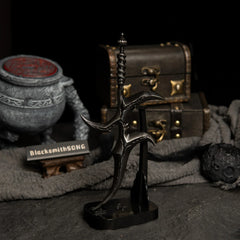 Vertical display of the Black Knife replica on an upright black stand against a dark background.
