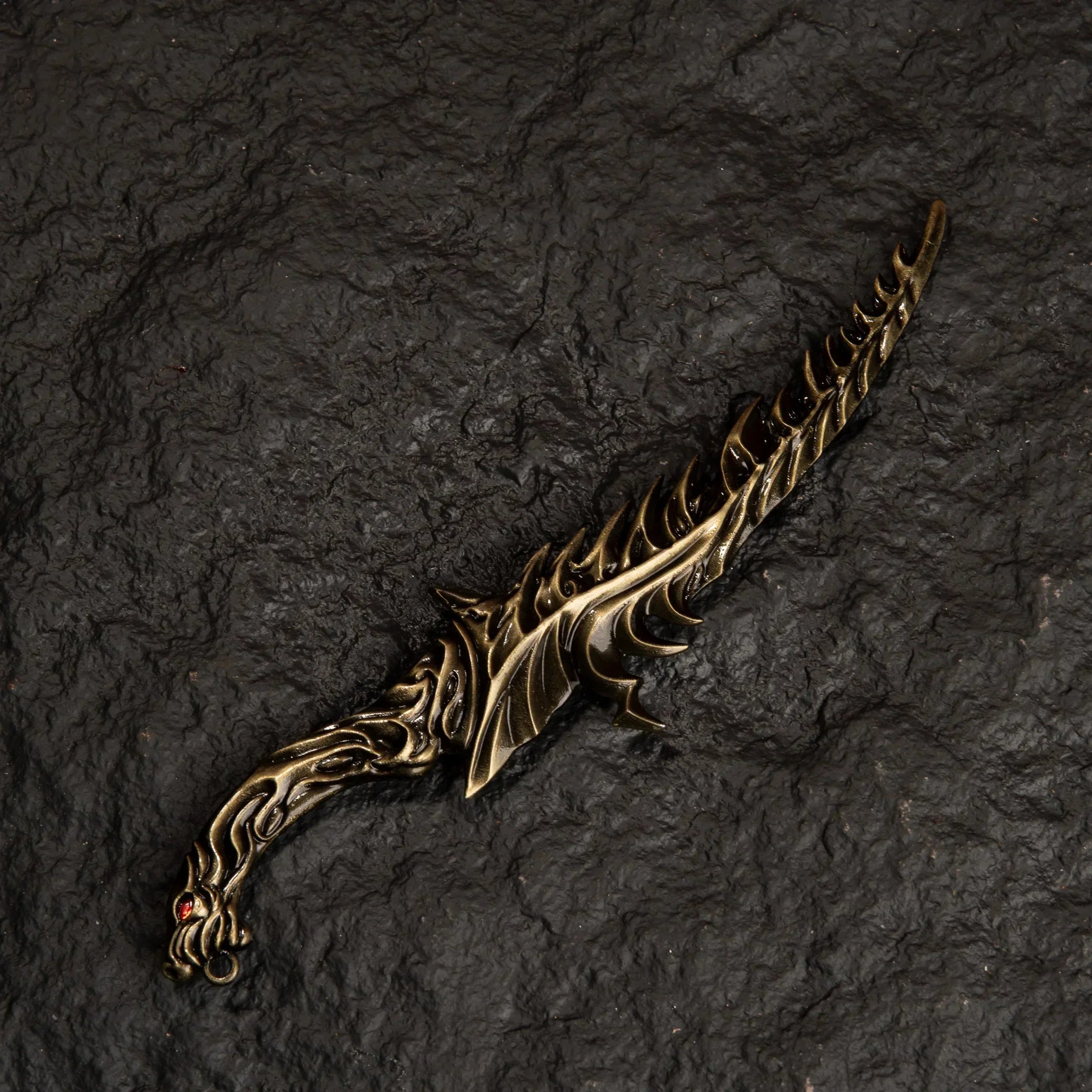 Reduvia dagger metal replica from Elden Ring isolated on a black background, showing its serrated blade profile.