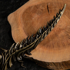 Macro shot of the Reduvia dagger replica blade, showing the sharp, teeth-like serrations along the edge.