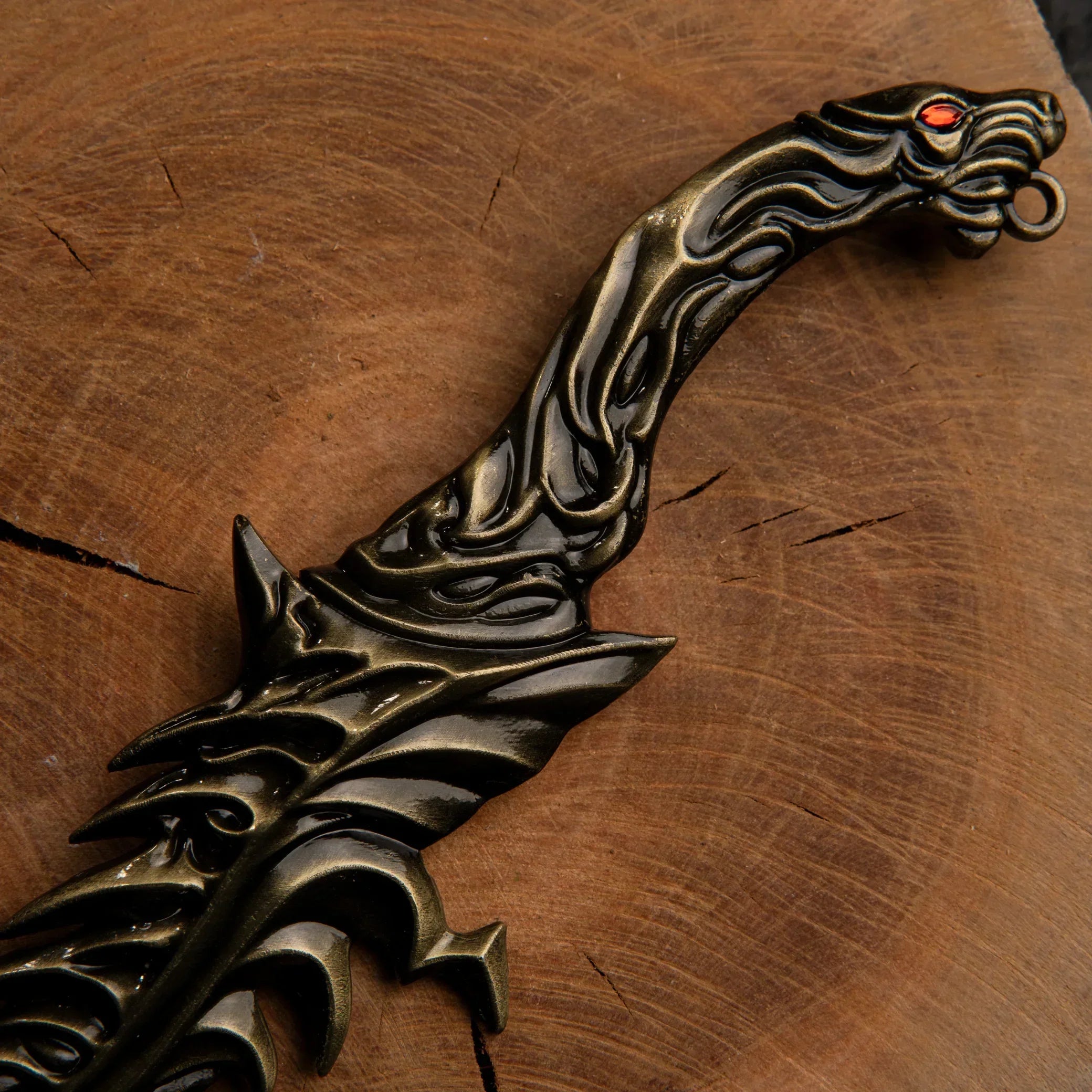 Close-up detail of the Reduvia dagger's handle and lower blade, highlighting the antique bronze and jagged metal texture.
