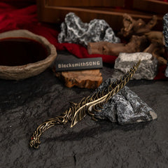 High-angle view of the Reduvia dagger replica on a dark textured surface with red cloth in the background.