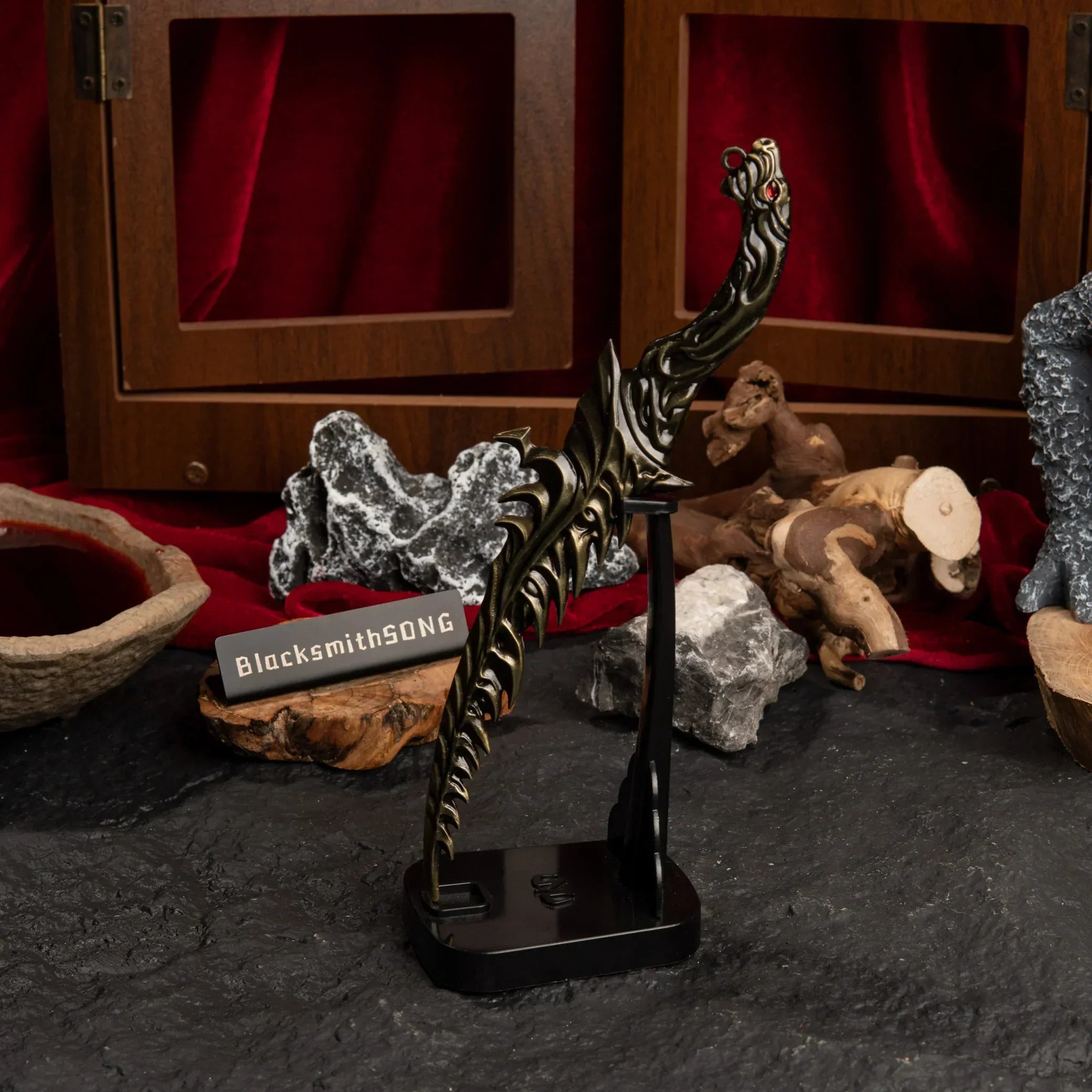 Vertical display of the Reduvia dagger on an upright black stand against a red background.