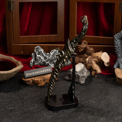 Vertical display of the Reduvia dagger on an upright black stand against a red background.