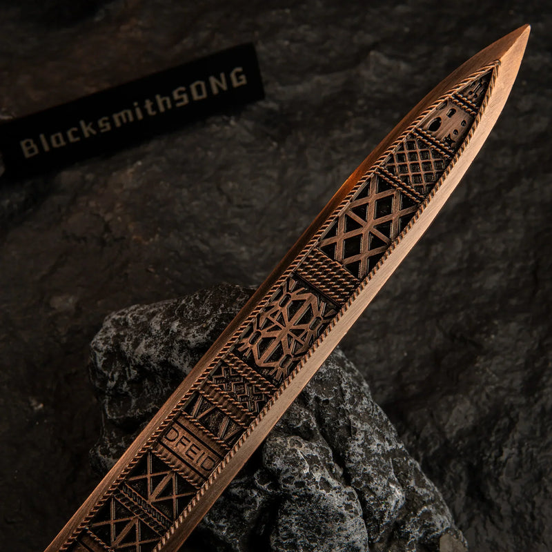 Macro shot of the blade texture on the Regalia of Eochaid replica, showing the intricate totem-like patterns.