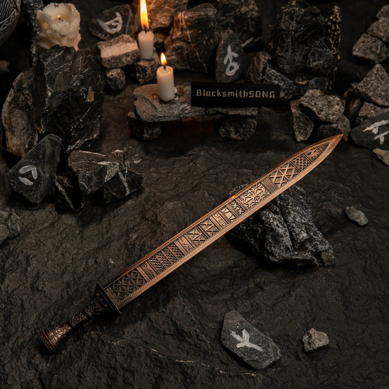 Regalia of Eochaid replica resting on dark rocks marked with white runic symbols, illuminated by candlelight.