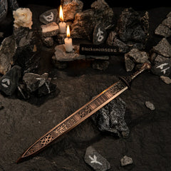 High-angle view of the Regalia of Eochaid sword on a textured stone surface with candles in the background.