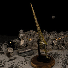 Vertical display of the Dragon King's Cragblade on an upright black stand against a dark background with rocks.