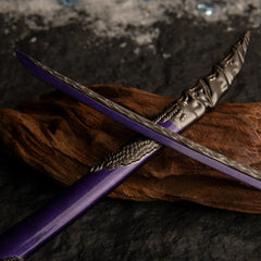Macro shot of the Dragonscale Blade katana crossing over its scabbard on dark wood, highlighting the metallic texture and purple hue.