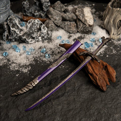 Dragonscale Blade replica resting on dark wood, surrounded by artificial snow, grey rocks, and scattered blue crystal props.