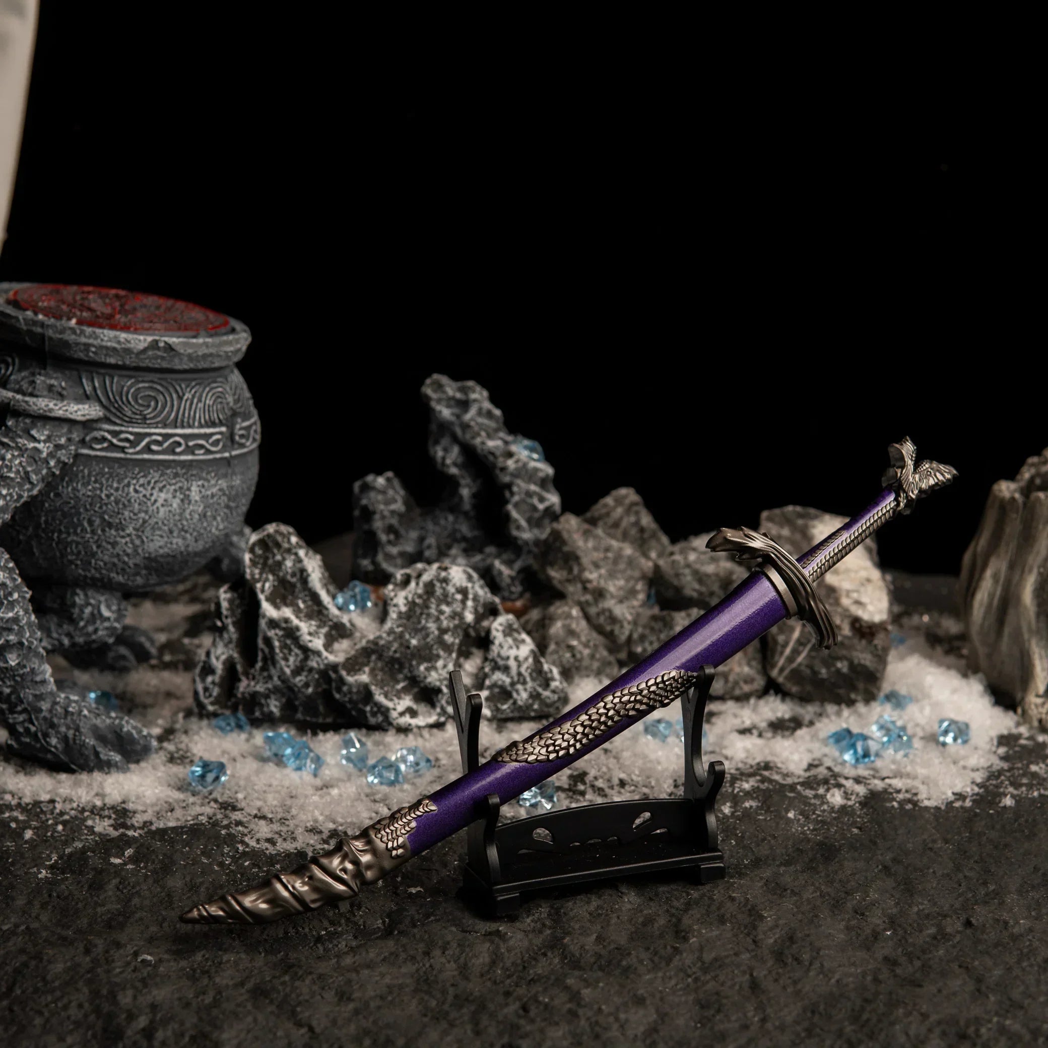 Side view of the Dragonscale Blade on a small display stand in a dark, snowy setting with blue crystals.