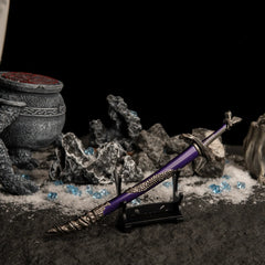 Side view of the Dragonscale Blade on a small display stand in a dark, snowy setting with blue crystals.