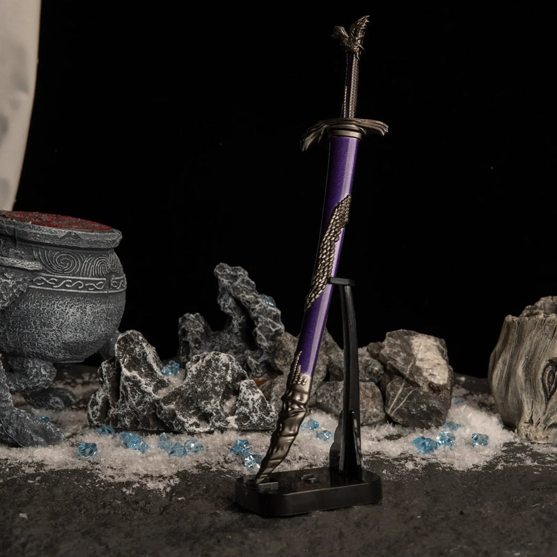 Vertical display of the Dragonscale Blade on an upright black stand against a dark snowy background.