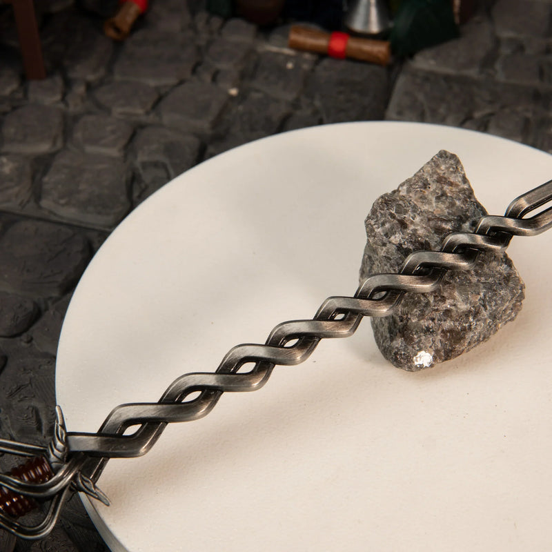 Detailed view of the wavy flamberge-style blade of the zinc alloy Fire Knight's Greatsword replica on cobblestones.