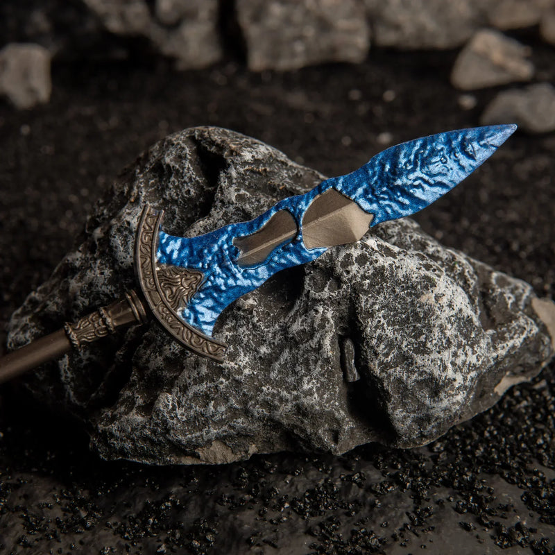 Close-up macro shot of one blue crystal blade tip of the Gargoyle's Black Blades replica resting on a dark rock.