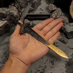 A hand holding the 21cm Gargoyle's Greatsword metal replica to show its scale, highlighting the bronze hilt and the golden tip.
