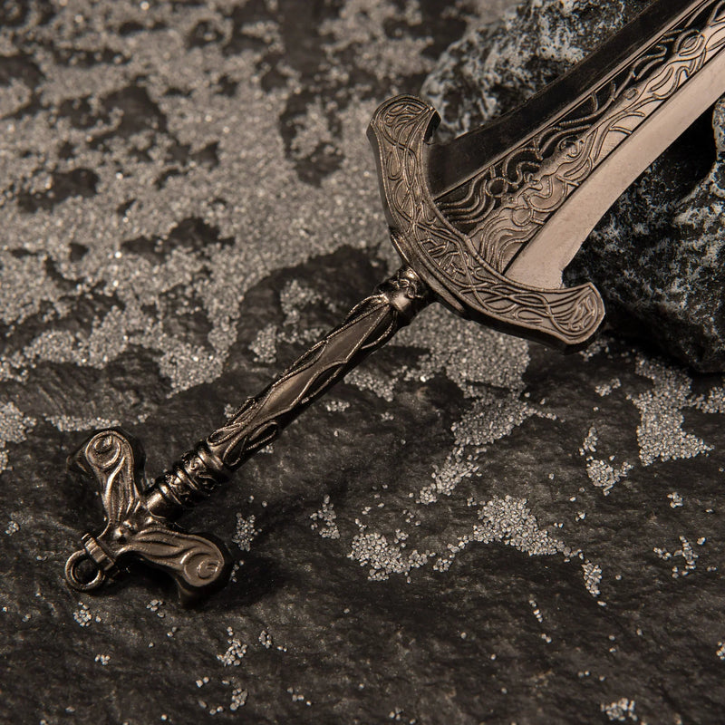 Macro close-up shot of the ornate bronze hilt and lower blade engravings of the Gargoyle's Greatsword metal miniature.