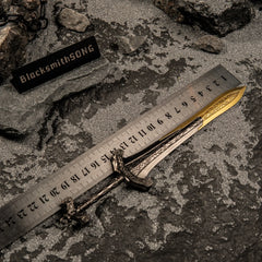 Gargoyle's Greatsword metal replica placed next to a metal measuring ruler on grey sand, showing a total length of 21 centimeters.