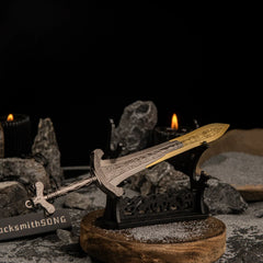 Angled shot of the Gargoyle's Greatsword on a large horizontal display stand, illuminated by a lit black candle in the background.