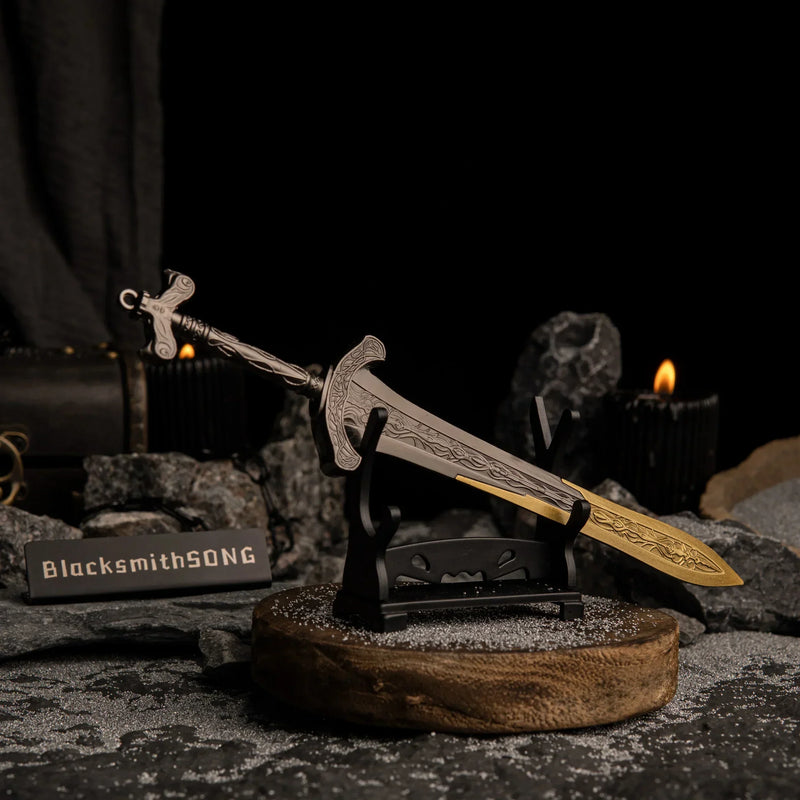 Gargoyle's Greatsword miniature resting horizontally on a small black stand, positioned on a wooden base surrounded by dark rocks.