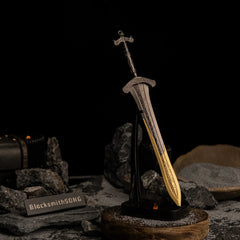 Vertical display of the Gargoyle's Greatsword replica on an upright black stand, set against a dark catacomb aesthetic background with grey sand.