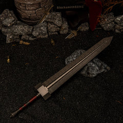 Wide angle view of the massive 30cm Greatsword metal miniature lying on dark rocks in a ruined battlefield setting with a stone tower in the background.
