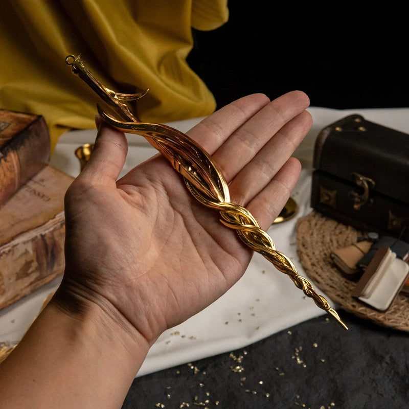 A hand holding the Greatsword of Damnation replica over a table with books and candles to show scale.