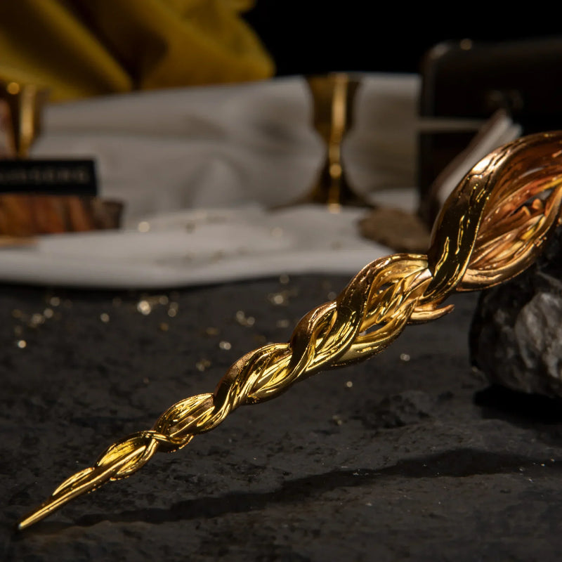 Macro detail of the twisted golden blade tip of the Greatsword of Damnation replica resting on a dark rock.