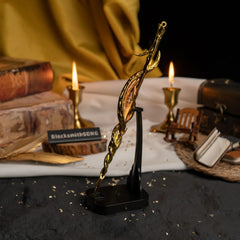 Vertical display of the Greatsword of Damnation on an upright black stand with lit candles and books.