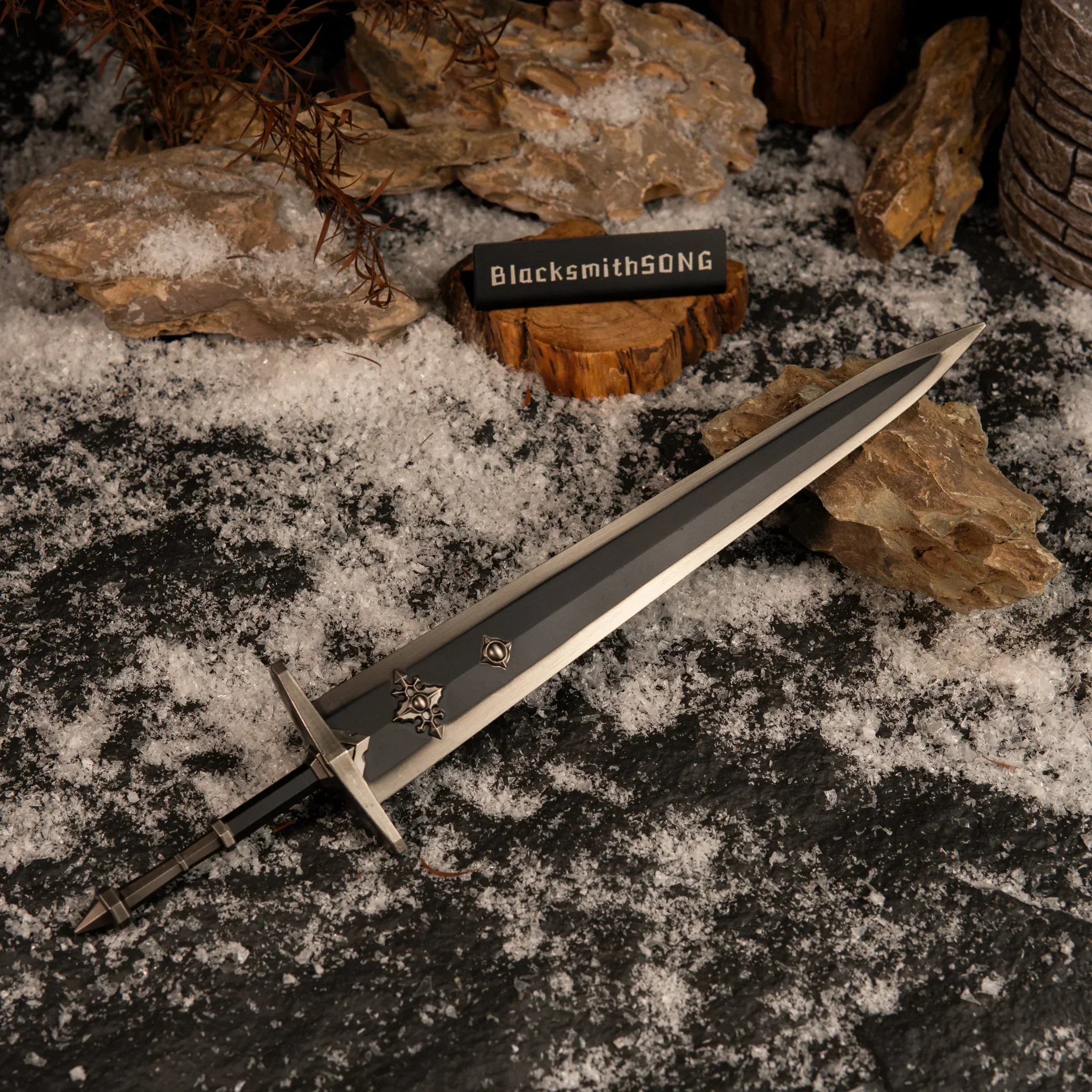 Top-down view of the Greatsword of Solitude lying on a dark stone surface covered in artificial snow.