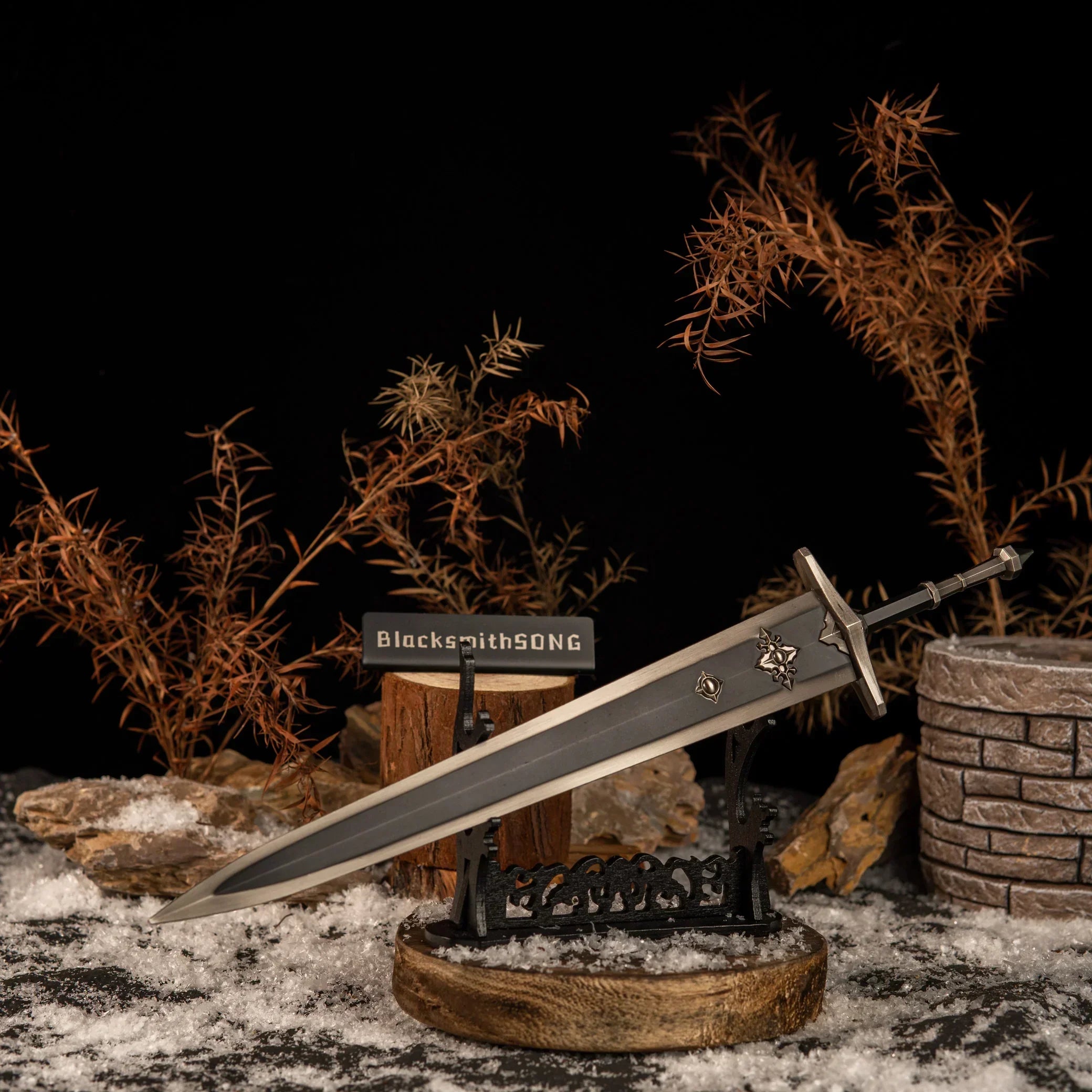 Greatsword of Solitude displayed horizontally on a large black sword stand with a wooden base in a snowy rock setting.