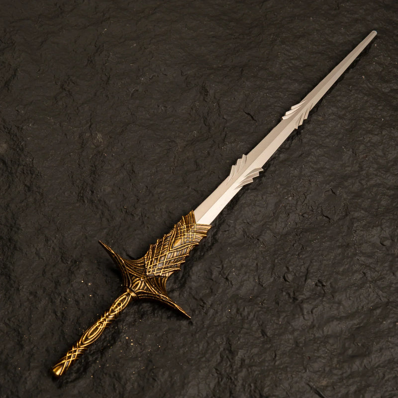 Solid metal replica of Leda's Sword from Elden Ring featuring an intricate gold handle, isolated on a textured black background.
