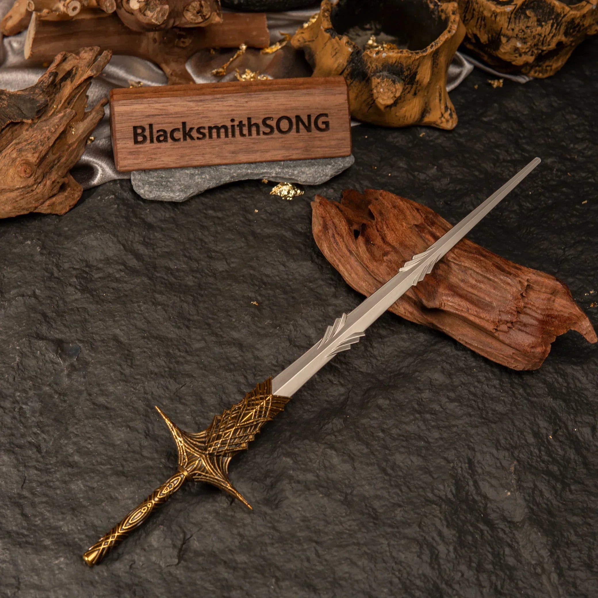 Overhead angled shot of the Leda's Sword miniature surrounded by rustic wood and dark rocks.