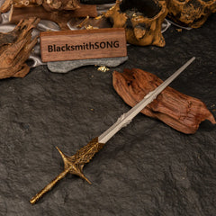 Overhead angled shot of the Leda's Sword miniature surrounded by rustic wood and dark rocks.