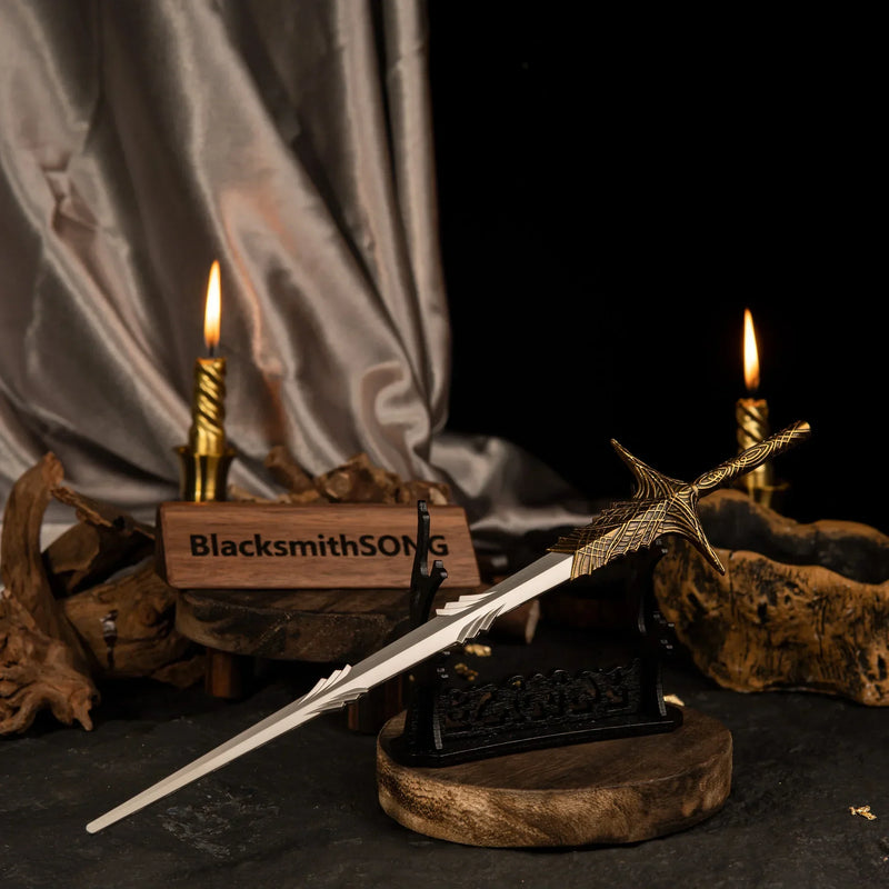 Leda's Sword metal replica displayed horizontally on a large black stand with dark silk fabric and lit candles in the background.