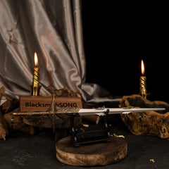 Angled view of Leda's Sword displayed on a compact stand with a BlacksmithSONG logo plate and dark aesthetic background.