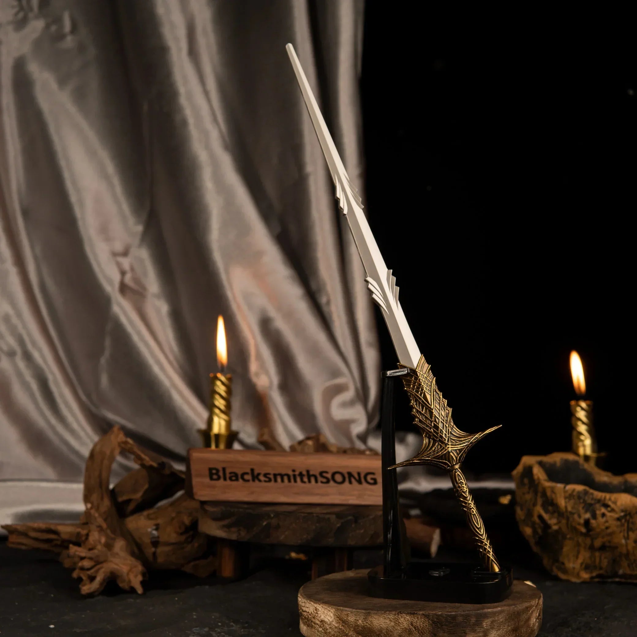 Vertical display of the Leda's Sword replica on an upright black stand, illuminated by a nearby lit candle and draped silk.