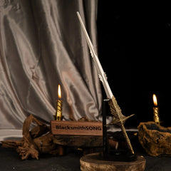 Vertical display of the Leda's Sword replica on an upright black stand, illuminated by a nearby lit candle and draped silk.
