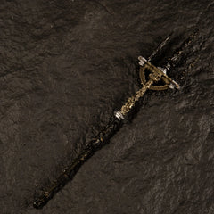 Angled view of the Mohgwyn's Sacred Spear metal miniature showing the intricate baroque engravings on the shaft, isolated on a black background.