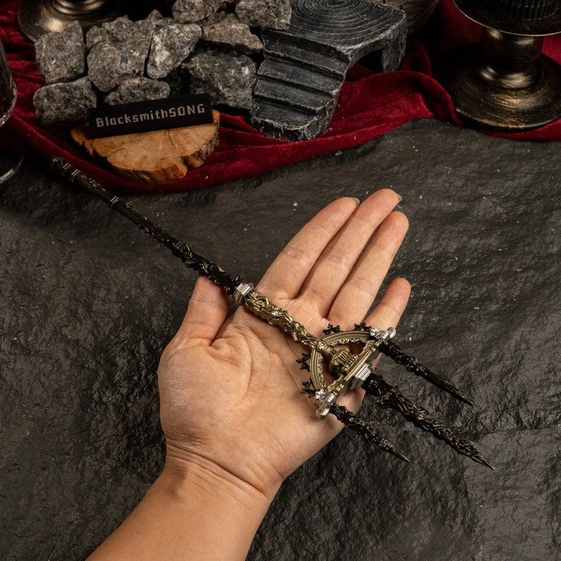 A human hand holding the 30cm Mohgwyn's Sacred Spear metal replica to demonstrate its size and scale against a dark, rocky studio background.